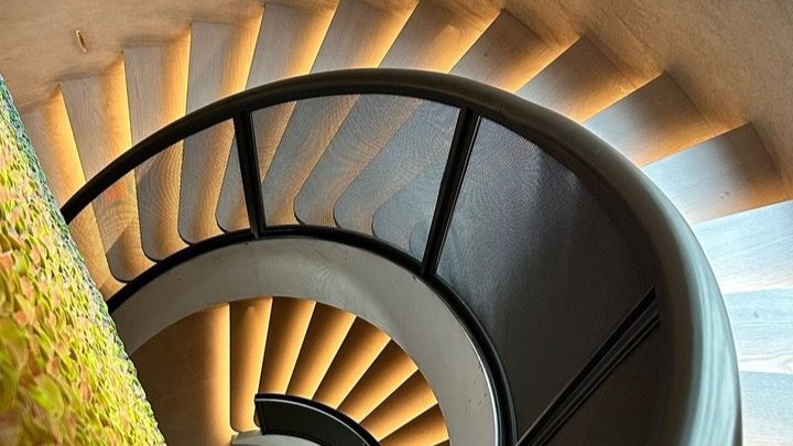Ronde trap met ledverlichting over twee verdiepingen